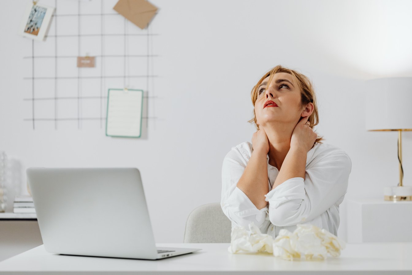 Woman in White Long Sleeve Shirt Sitting at a Table Looking Up